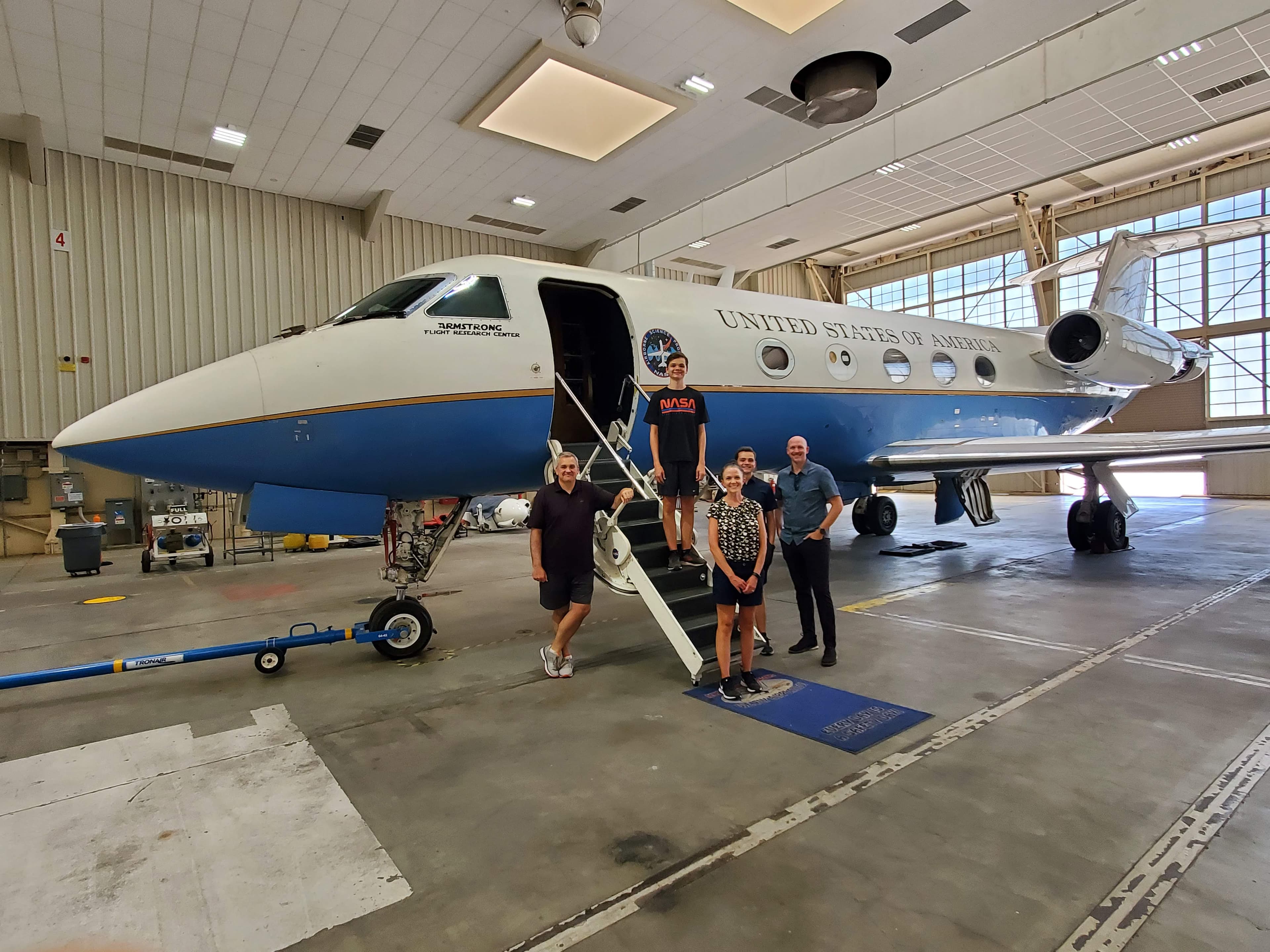 Group standing in front of a NASA Gulfstream aircraft in a hangar