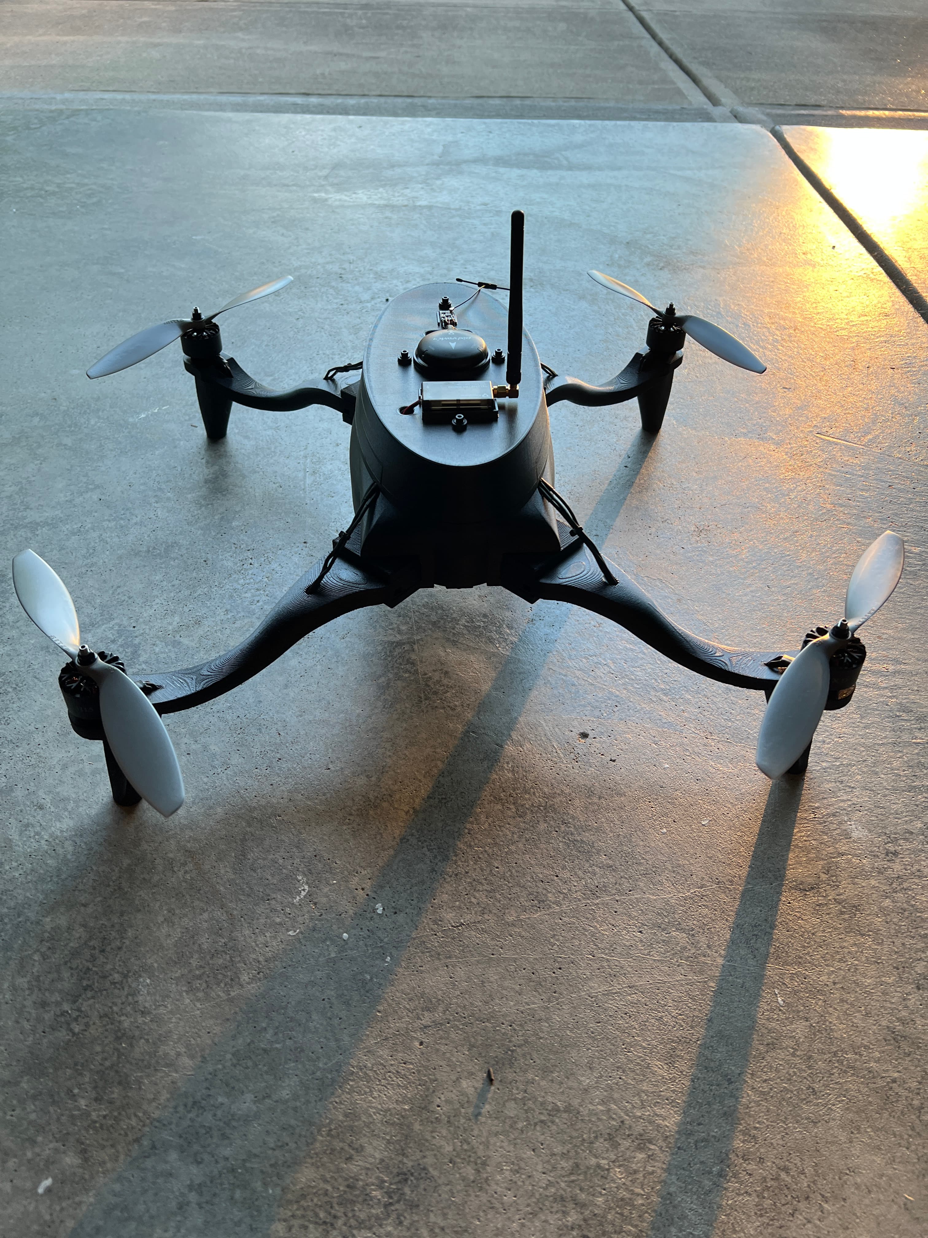 Completed four-rotor drone resting on pavement