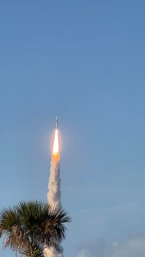 Rocket ascending against a clear blue sky